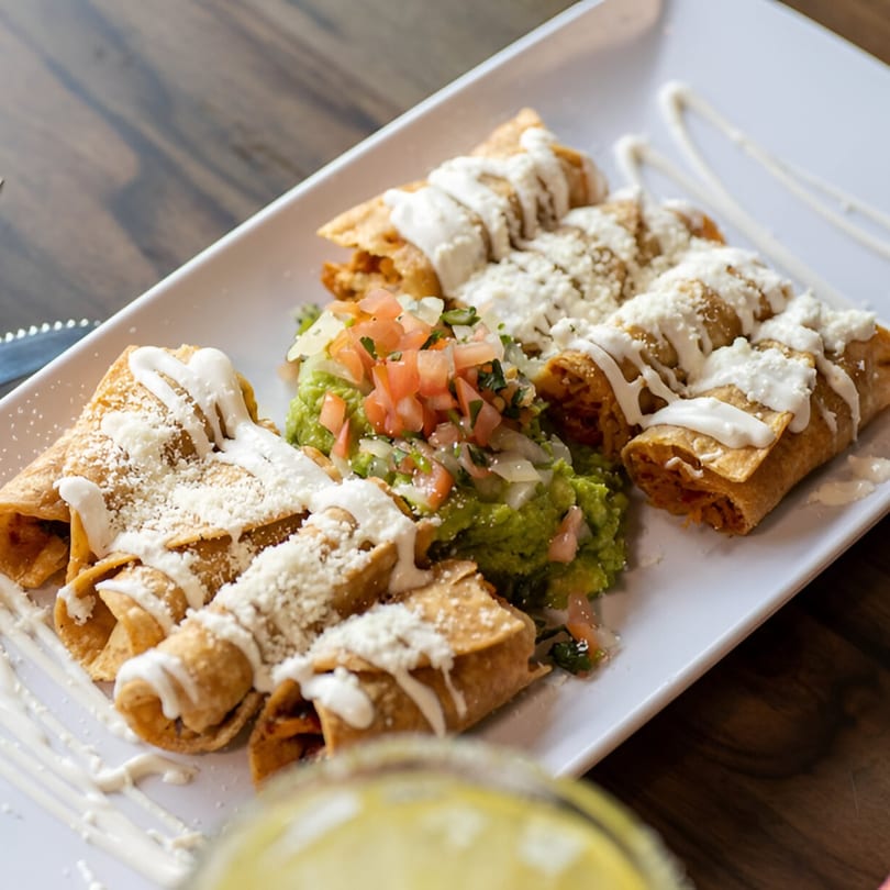 Crispy taquitos drizzled with crema and cheese, served with guacamole and pico de gallo.