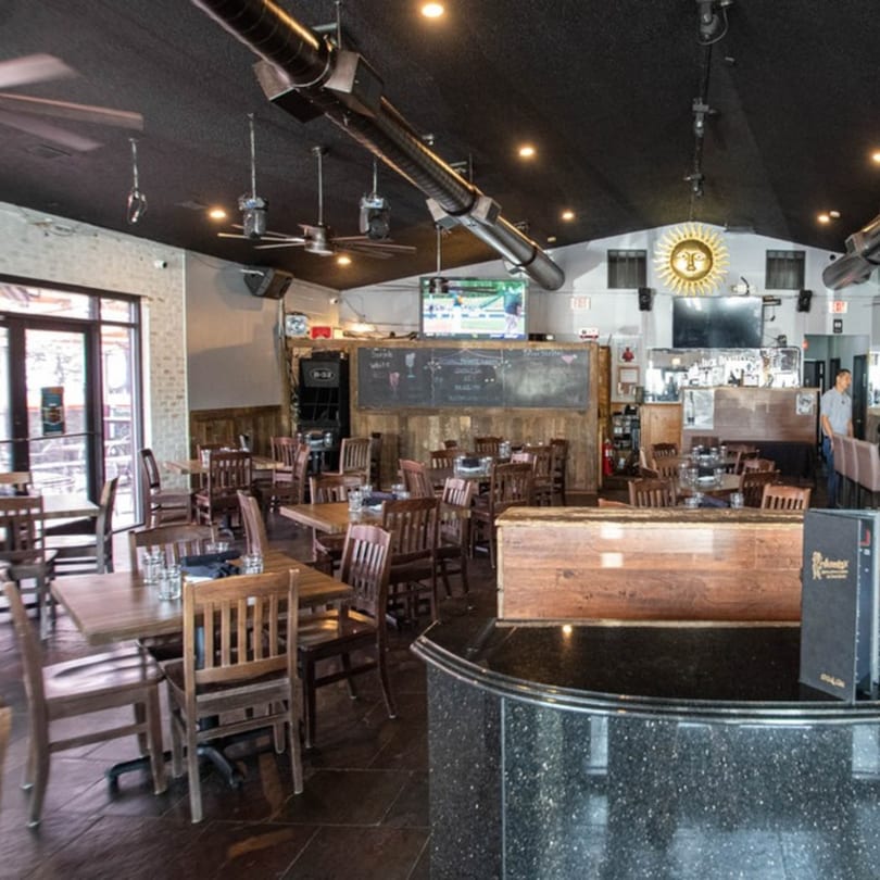 Alejandra's Mexican Restaurant dining room with wooden tables, chairs, and a bar area.